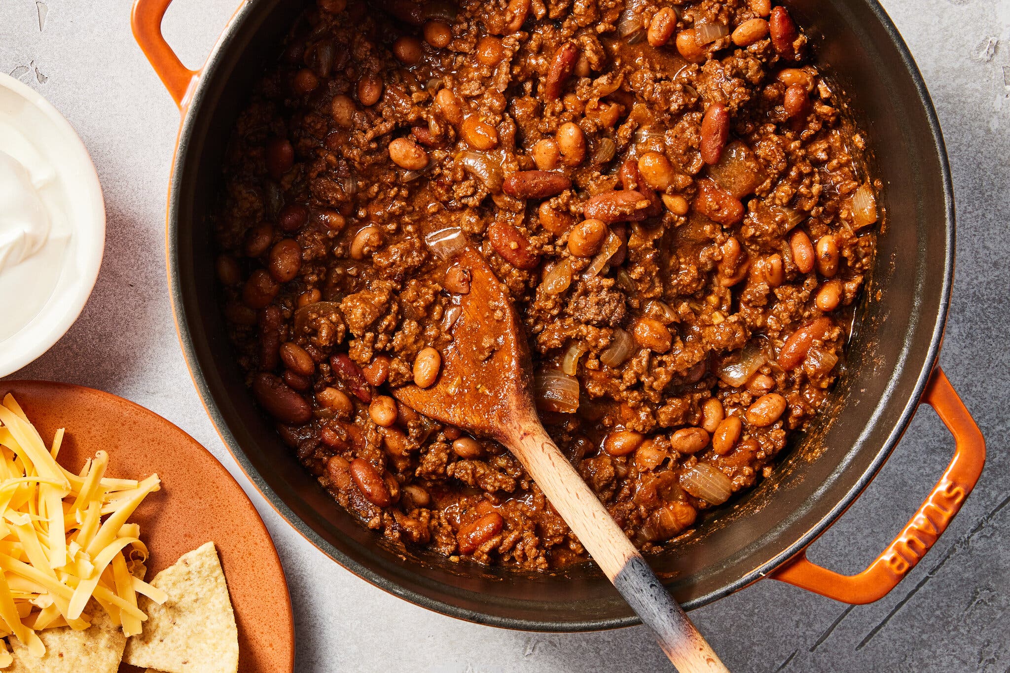 An overhead image of a meat and bean chili in a Dutch oven.