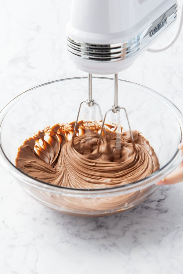 Whipping ganache with an electric hand mixer.