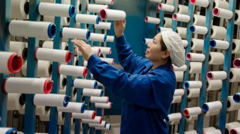 Getty Images This photo taken on February 22, 2018 shows a woman working at a textile factory in Haian in China's eastern Jiangsu province.