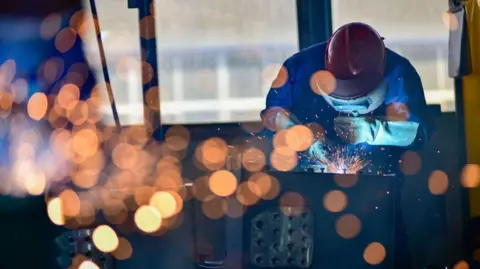 Getty Images Workers weld parts at a factory which produces cabs for excavators in Qingzhou, in China's eastern Shandong province on October 31, 2024