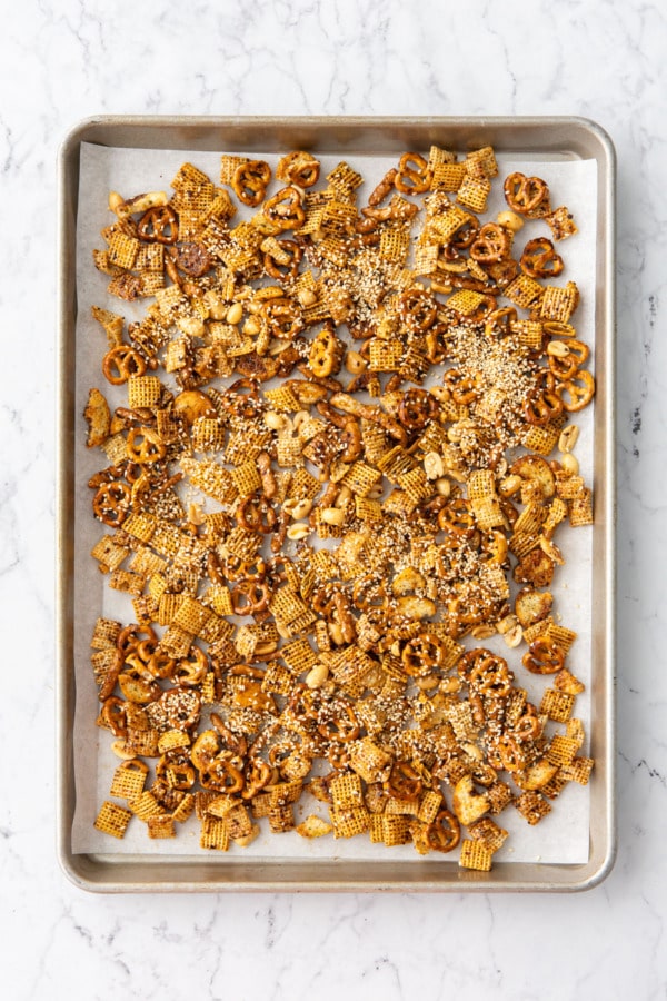 Overhead, snack mix on a baking sheet ready to bake.