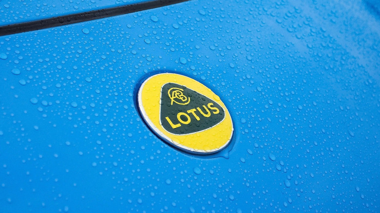 A closeup of the front part of the blue Lotus automobile with a Lotus logo
