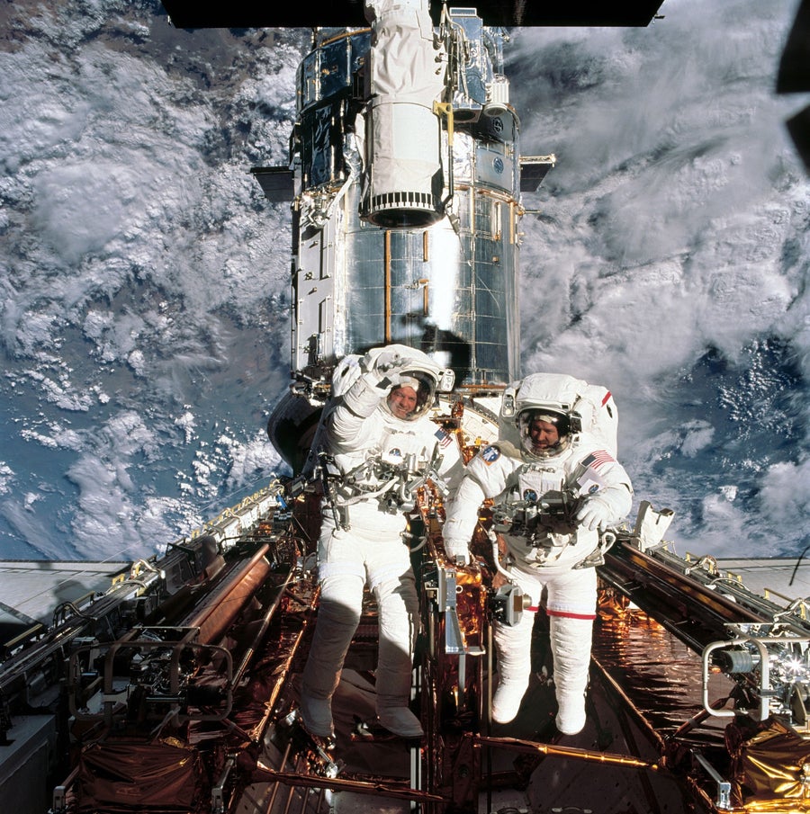 Astronauts John M. Grunsfeld (right) and Richard M. Linnehan (left) service the Hubble Space Telescope on March 8, 2002